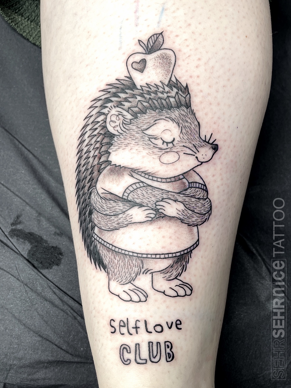 Igel Tattoo mit Schriftzug „Self Love Club“ in Schwarz-Grau