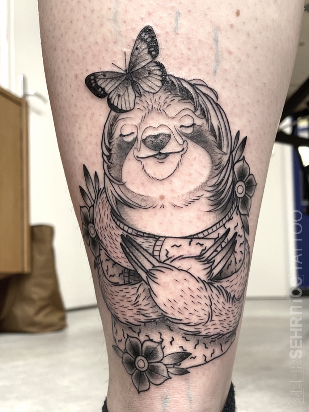 Faultier Tattoo mit Schmetterling und Blumen in Schwarz-Grau