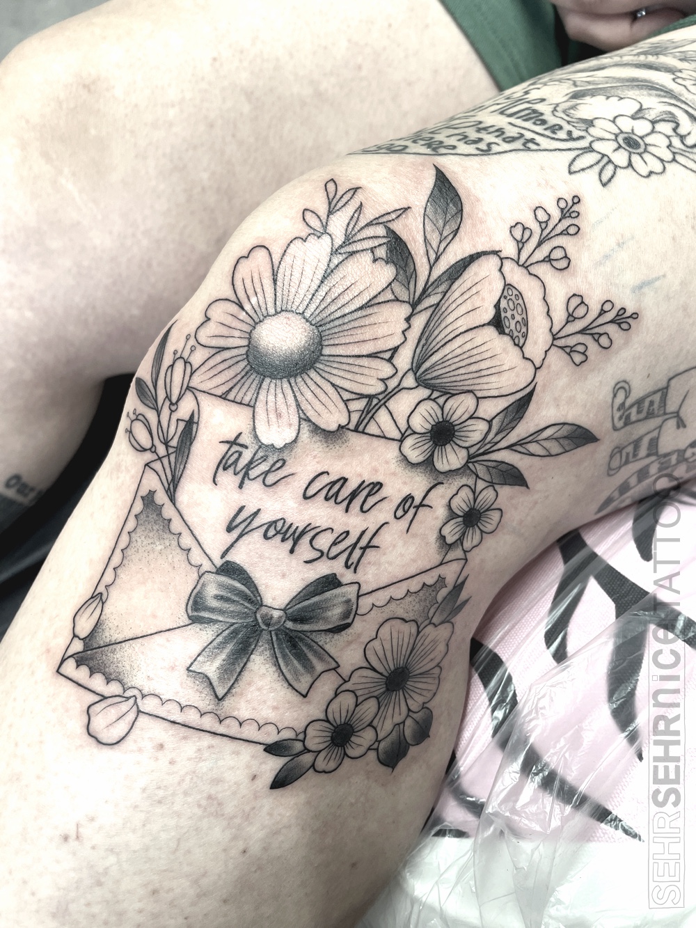 Brief Tattoo mit Blumen und Schriftzug „take care of yourself“ in Schwarz-Grau