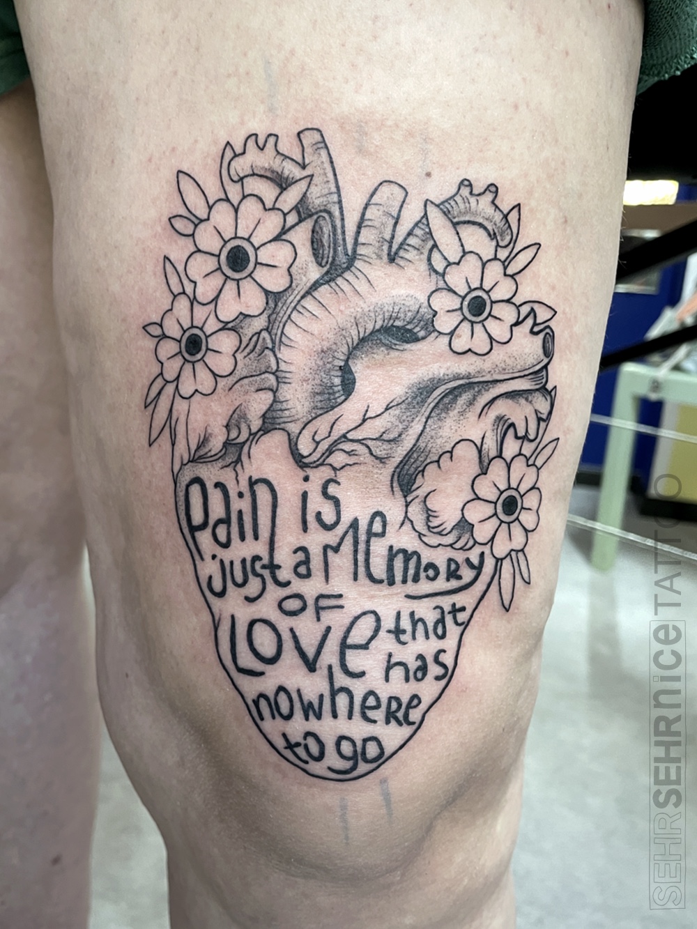 Anatomisches Herz Tattoo mit Blumen und Schriftzug in Schwarz-Grau